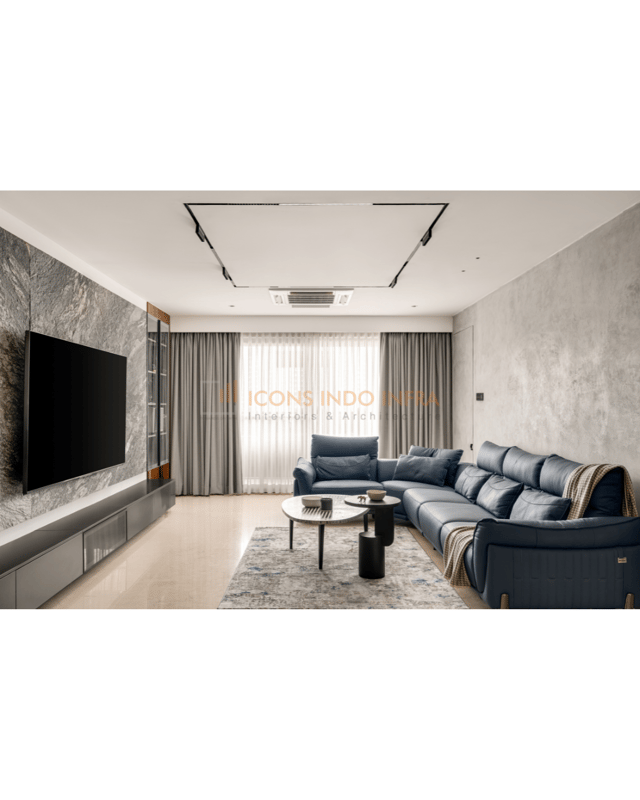 Modern living room in Hyderabad with blue leather sectional, stone TV feature wall, grey drapes and round marble coffee tables