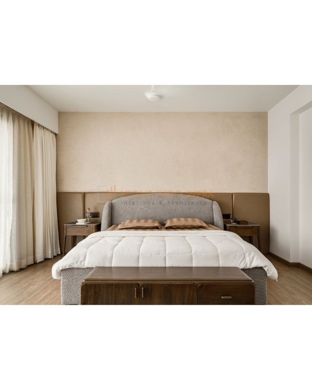 Master bedroom in warm neutrals, upholstered headboard, twin nightstands and a wooden bench at the foot of the bed