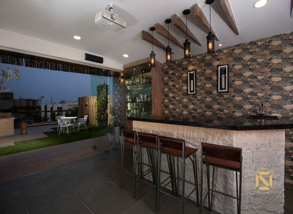 Rooftop terrace at dusk with bamboo pergola, white cast-iron bistro set, artificial lawn and warm ambient lighting, Hyderabad