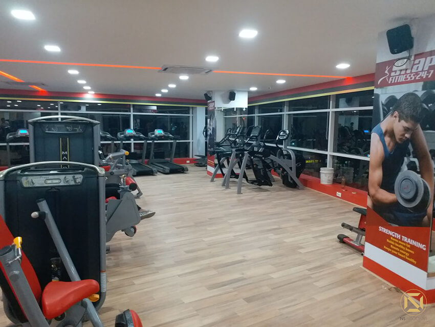 Snap Fitness gym floor with treadmills, strength machines and wood flooring under bright lights, Hyderabad