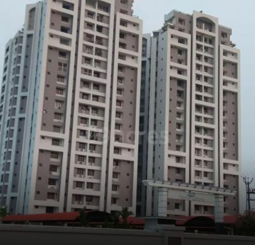 Tall residential apartment towers with balconied facades against an overcast sky, Hyderabad