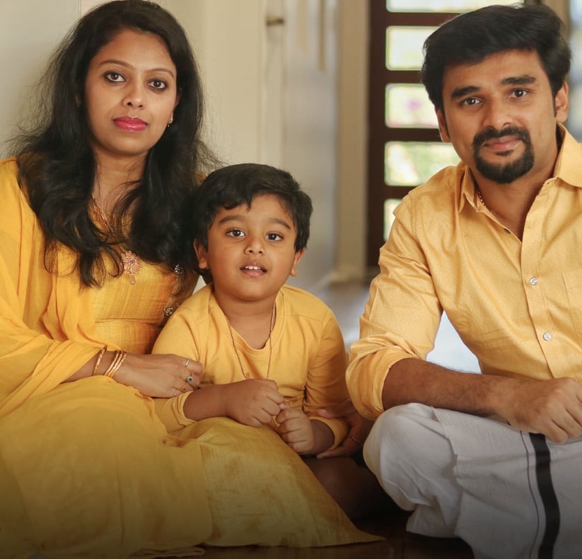 Family of three in coordinated yellow Kerala attire, homeowner portrait for a Hyderabad full-home interior project