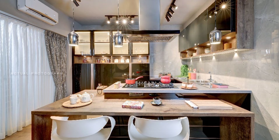 Modern kitchen with concrete countertop, red gas hob, glass pendant lights and breakfast bar with white moulded chairs, Hyderabad